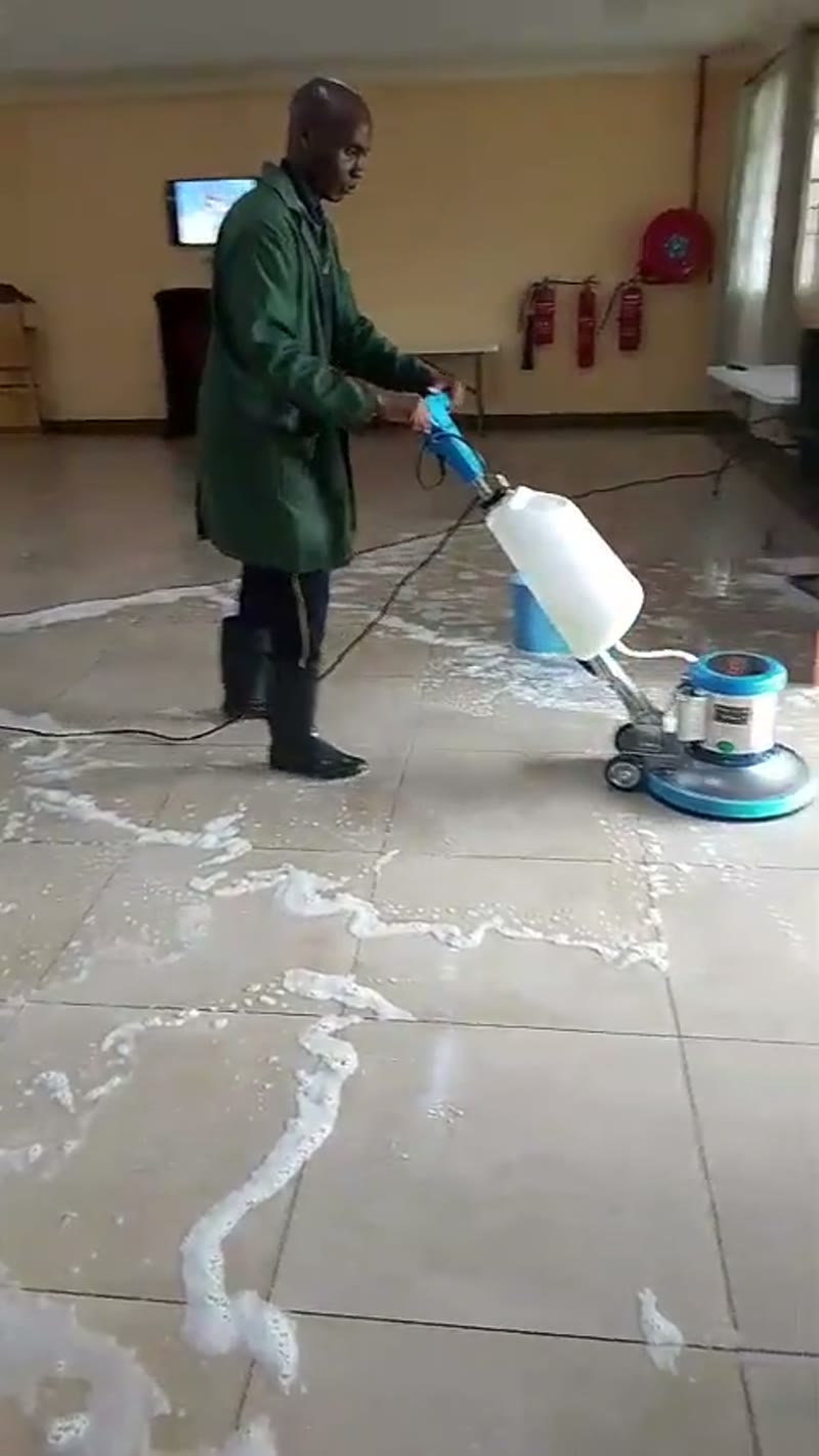 Dorsa cleaning technician operating a floor scrubbing machine